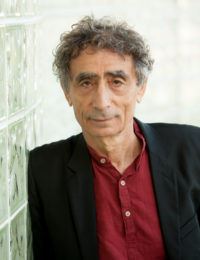 headshot of Dr. Gabor Mate who is leaning against a glass block wall